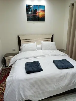 a large white bed with two blue towels on it at براديس الاحياء in Hurghada