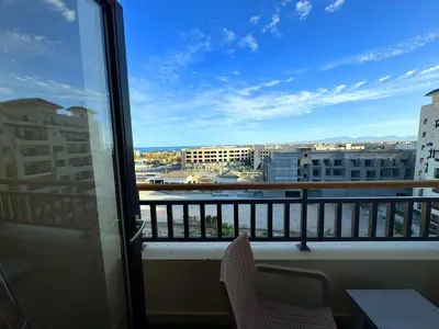 a balcony with chairs and a view of a city at More Relaxation Aldau Heights Studio in Hurghada in Hurghada
