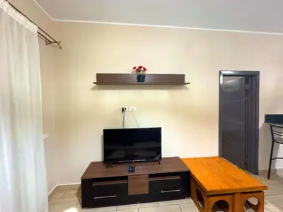a living room with a tv and a table at Coral Aldau Heights one bedroom apartment in hurghada in Hurghada