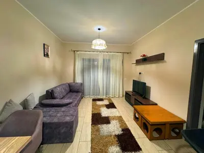 a living room with a purple couch and a tv at Coral Aldau Heights one bedroom apartment in hurghada in Hurghada