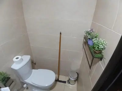a bathroom with a toilet and plants on the wall at Crystal Aldau Heights one bedroom apartment in Hurghada in Hurghada