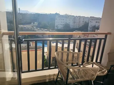 a balcony with two chairs and a view of a city at Crystal Aldau Heights one bedroom apartment in Hurghada in Hurghada