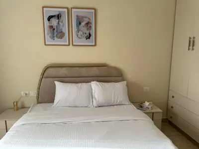 a bedroom with a bed with two pictures on the wall at Paradise Aldau Heights one bedroom apartment in Hurghada in Hurghada
