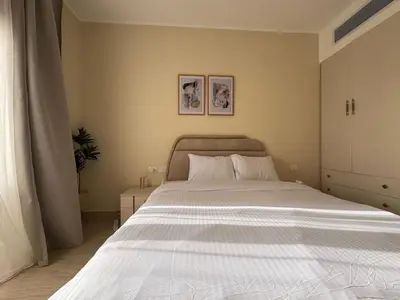 a bedroom with a large bed with white sheets at Paradise Aldau Heights one bedroom apartment in Hurghada in Hurghada