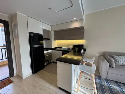 a kitchen and living room with a couch and a table at Paradise Aldau Heights one bedroom apartment in Hurghada in Hurghada