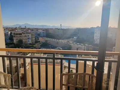 a balcony with chairs and a view of a city at Paradise Aldau Heights one bedroom apartment in Hurghada in Hurghada