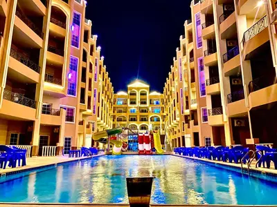a swimming pool in the middle of a building with blue chairs at B1-04 Juliana in Hurghada