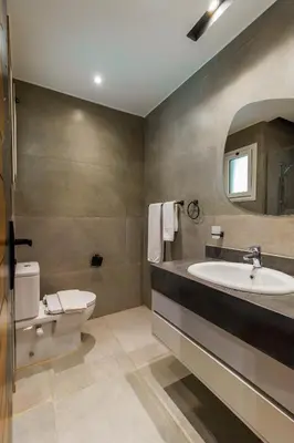 a bathroom with a sink and a toilet and a mirror at Al Saraya Sahl Hasheesh by Peaks One Bedroom Apartment with Pool View C201 in Hurghada