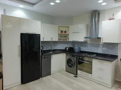 a kitchen with a black refrigerator and a dishwasher at Princess Resort apartment Hurghada in Hurghada