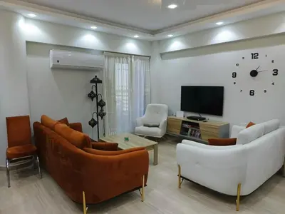 a living room with couches and a flat screen tv at Princess Resort apartment Hurghada in Hurghada