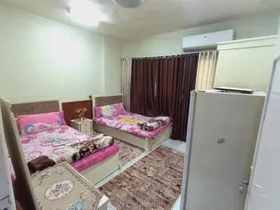 a small room with two beds and a refrigerator at Aswan cozy apartment in Aswan