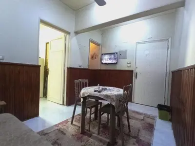 a room with a table with chairs and a television at Aswan cozy apartment in Aswan