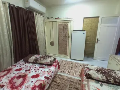a room with two beds and a refrigerator at Aswan cozy apartment in Aswan
