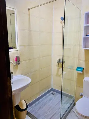 a bathroom with a shower with a sink and a toilet at The Modern Nest Magawish in Hurghada