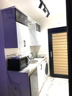 a small kitchen with a sink and a microwave at The Modern Nest Magawish in Hurghada