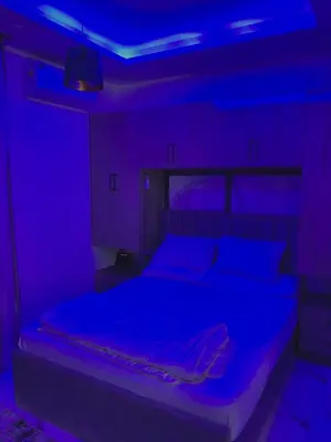 a bedroom with a bed with a blue light at The Modern Nest Magawish in Hurghada