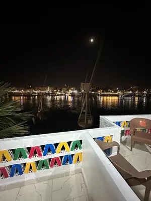 a white railing with a view of the water at night at Anno ka in Jazīrat Aswān