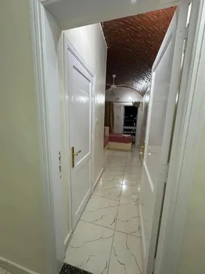 a hallway with a white door and a tile floor at Anno ka in Jazīrat Aswān