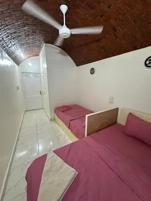 a bedroom with two beds and a ceiling fan at Anno ka in Jazīrat Aswān