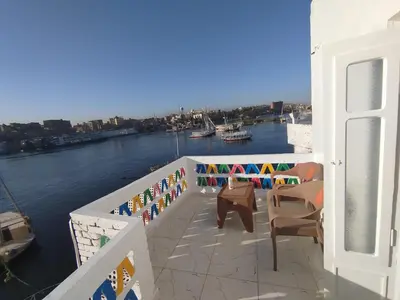 a balcony with chairs and a view of a river at Anno ka in Jazīrat Aswān
