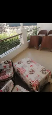 a room with two beds and chairs and a balcony at Luxor Egypt in Al Baghdādī
