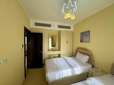 a bedroom with two beds and a chandelier at Beauty Aldau heights in Hurghada