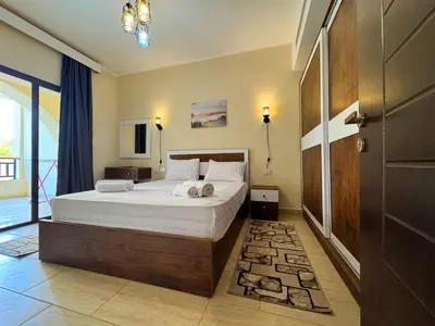 a bedroom with a bed with white sheets and pillows at Diamond Aldau in Hurghada