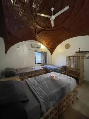 two beds in a room with a ceiling at Torya guesthouse in Aswan