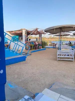 a playground with benches and an umbrella at Torya guesthouse in Aswan