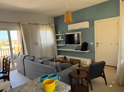 a living room with a couch and a tv at El Gouna 2 BR Apartment in Hurghada