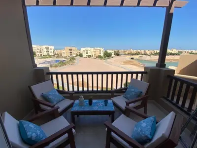a balcony with chairs and a table with a view at El Gouna 2 BR Apartment in Hurghada