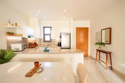 a kitchen with a table and a refrigerator at Bright Shedwan 3BR • Modern Townhouse in Hurghada