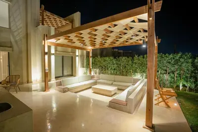 a patio with a couch under a wooden pergola at Bright Shedwan 3BR • Modern Townhouse in Hurghada