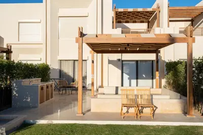 a patio with two chairs and a wooden pergola at Bright Shedwan 3BR • Modern Townhouse in Hurghada