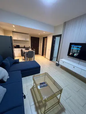 a living room with a blue couch and a glass table at 1-Bedroom Aldau Heights in Hurghada