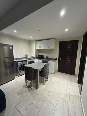a kitchen with a table and chairs in a room at 1-Bedroom Aldau Heights in Hurghada