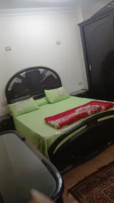 a bedroom with a green bed and a chair at الاقصر امتداد ش التليفزيون in Al Bayāḑīyah