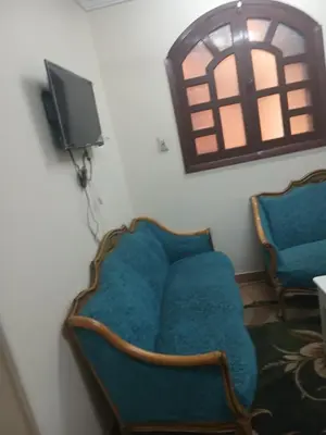a room with two blue chairs and a tv at الاقصر امتداد ش التليفزيون in Al Bayāḑīyah
