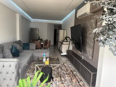 a living room with a couch and a tv at Modern 2 Bedroom Apartment with Private Beach Hurghada in Hurghada