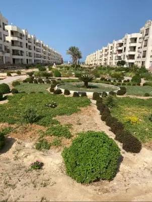 a garden in front of a large apartment building at Modern 2 Bedroom Apartment with Private Beach Hurghada in Hurghada