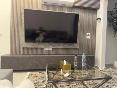 a living room with a large television on a wall at Modern 2 Bedroom Apartment with Private Beach Hurghada in Hurghada