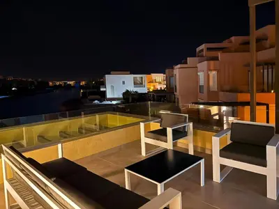 a balcony with chairs and a table on a building at Vibrant 3BR Villa - Free Pool & Lagoon Access At ElGouna in Hurghada
