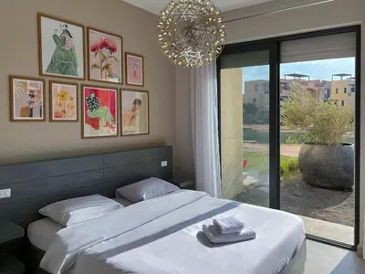 a bedroom with a bed and a chandelier at Vibrant 3BR Villa - Free Pool & Lagoon Access At ElGouna in Hurghada