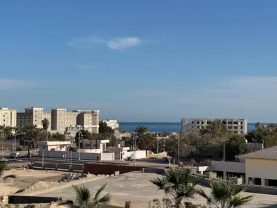 a view of a city with buildings and palm trees at Sun & Fun Aldau Heights one bedroom apartment in hurghada in Hurghada