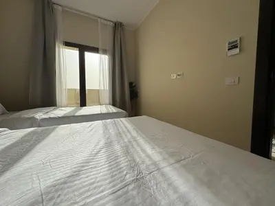 a bedroom with two beds and a window at Aldau Heights one bedroom apartment in Hurghada cr in Hurghada