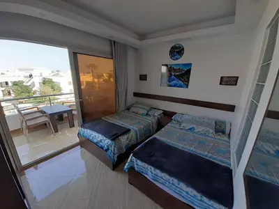 a bedroom with two beds and a balcony at Cecilia resort Hurghada in Hurghada