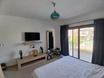 a bedroom with a bed and a tv and a window at Gcribs B7F7 in El Gouna