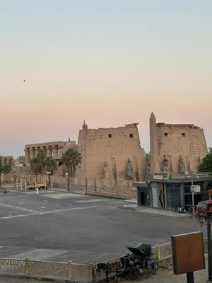 a parking lot in front of two large brick buildings at Temple & Nile view in Luxor