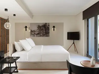 a white bedroom with a large bed and a table at The Chedi El Gouna in Hurghada