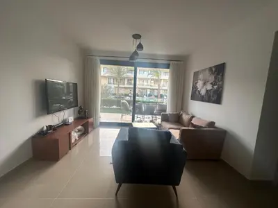 a living room with a couch and a tv at Hotel apartment in G cribs 2BR in El Gouna